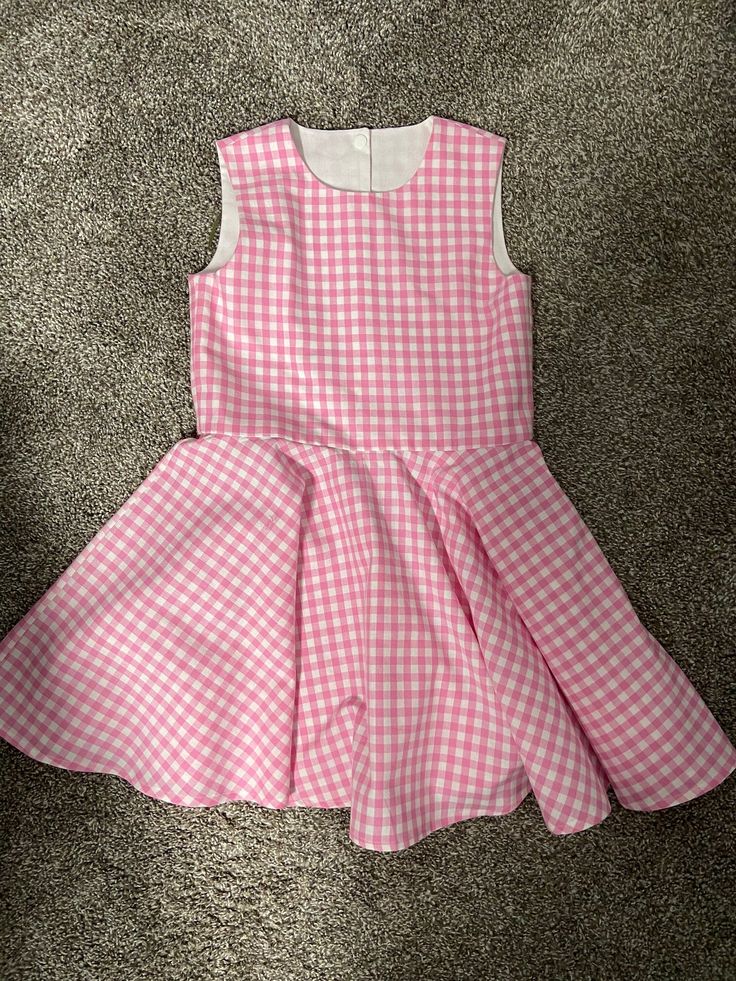 Beautiful  Barbie inspired pink gingham checked twirl dress..  The gingham fabric is Robert Kaufman  cotton.  The sleeveless dress has a fully lined bodice.  The back closes with kam Plastic  snaps.  The dress has a full circle twirl for that little dancer.    I would be happy to make this dress in other colors or fabric.  available in sizes 12 months to size 8  Measurements will be in the photo section Spring Gingham A-line Dress, Playful Sleeveless Gingham Dress, Pink Spring Dress For Picnic, Sleeveless Gingham Dress With Ruffles, Spring Plaid A-line Dresses, Cute Spring Plaid Dress, Playful Gingham Dress For Spring, Playful Gingham Dress With Ruffles, Spring Playful Gingham Dress