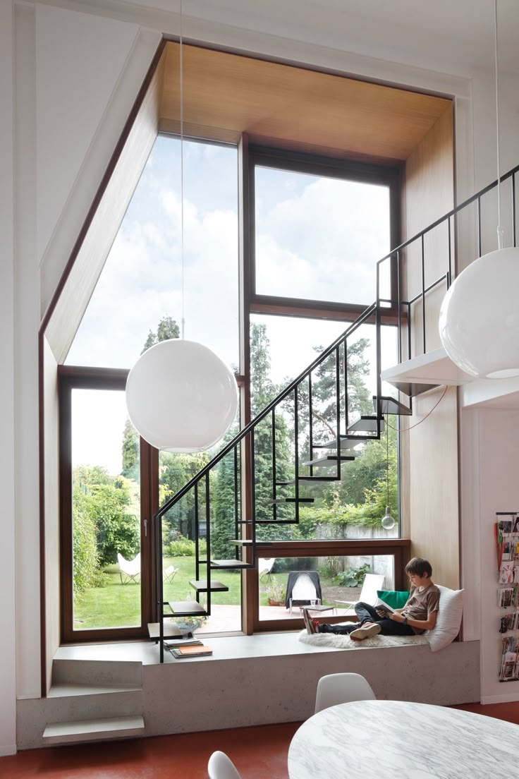 a person sitting on a window sill reading a book