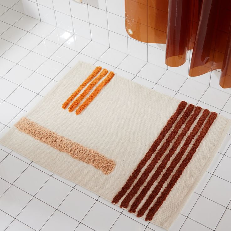 a bathroom rug with orange and brown stripes on it