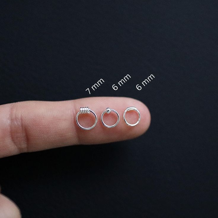 These ultra-tiny hoops, crafted from high-quality sterling silver, are perfect for second or third piercings, cartilage piercings, or a discreet touch of shine, these tiny hoops offer versatile styling options. Their minimal size makes them ideal for layering with other earrings or for wearing alone as a subtle, elegant accessory. * Material: 925 Sterling Silver * Design: Petite tiny hoops with a sleek, polished finish * Thickness: Approximately 0.6 mm for a delicate, barely-there feel * Hypoall Tiny Minimalist Small Hoop Piercings, Minimalist Internally Threaded Huggie Nose Rings, Minimalist Nickel-free Huggie Nose Rings, Tiny Hoop Nose Rings For Everyday Wear, Minimalist Hypoallergenic Huggie Nose Ring, Minimalist Sterling Silver Small Hoop Septum Ring, Minimalist Internally Threaded Hoop Nose Ring, Minimalist Hypoallergenic Sterling Silver Nose Ring, Minimalist Tiny Hoop Septum Ring