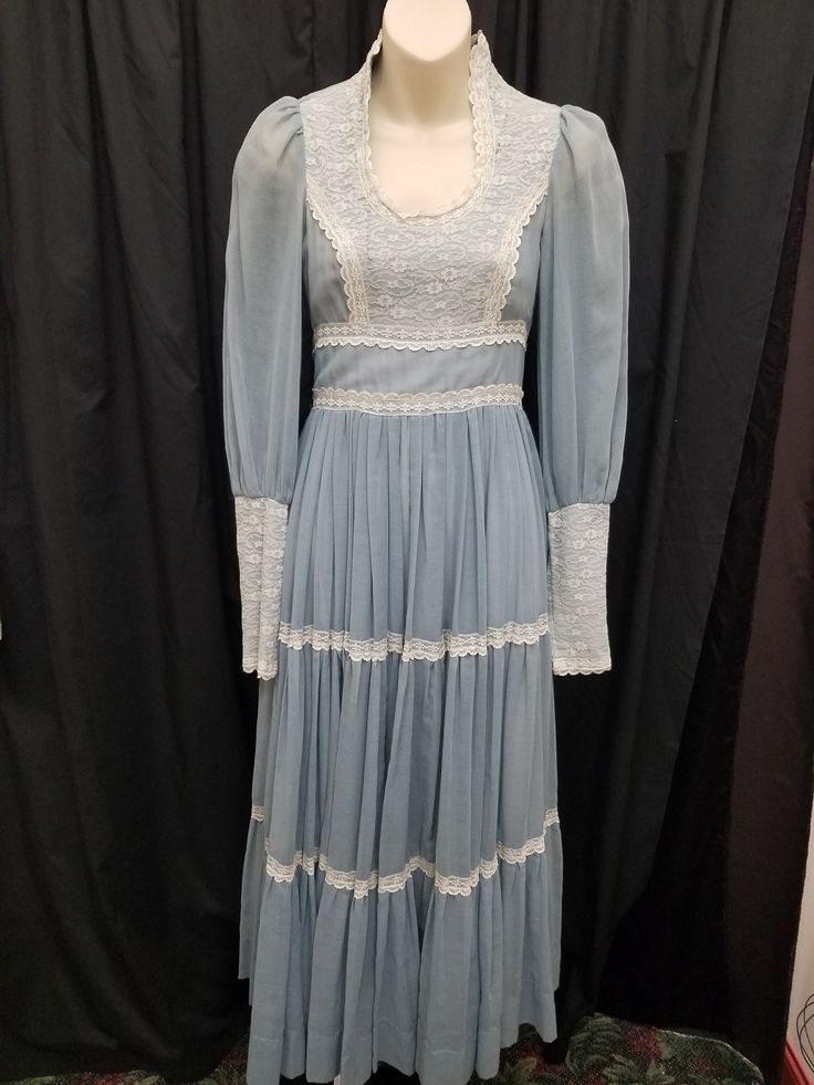 Vintage 1970's Soft Blue Lace Sweetheart Long-Sleeved Gunne Sax Brand Dress, Rare, Collector - see pics.   Dress is in excellent condition and has not been dry-cleaned.  Dress has a gorgeous sweetheart neckline with lace accents, tie-back belt, back zipper closure, sheer sleeves with lace detail and zipper at the wrists, and is lined with an underskirt. Measurements: waist 26, bust 30, sleeve 25, length 52, shoulder to shoulder 13 inches. Blue Vintage Victorian Dress With Ruffles, Blue Long Sleeve Cottagecore Dress, Vintage Blue Victorian Daywear Dress, Fitted Blue Victorian Vintage Dress, Blue Vintage Victorian Dress For Daywear, Blue Vintage Dress For Vintage Events, Blue Vintage Dress For Wedding, Vintage Blue Victorian Dress For Spring, Fitted Vintage Prairie Dress For Vintage Events