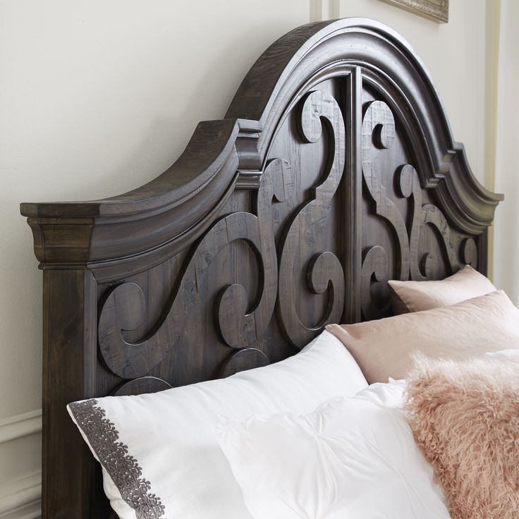 a bed with white pillows and a wooden headboard