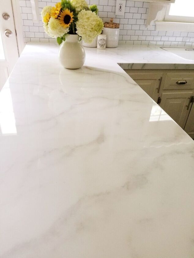 a white counter top in a kitchen with yellow and white flowers on the countertop