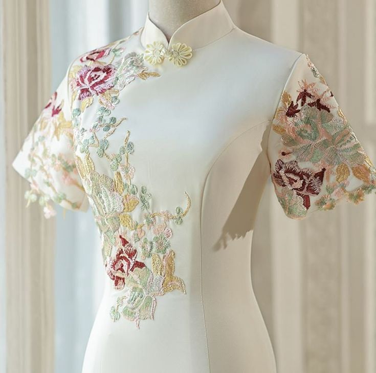 A beautiful fitted qipao with embellishments. Great for cocktail parties, wedding reception dinners and also graduation.  Please note this is a light champagne color, and not white. It is also a little small, so we do suggest you to size up after cross checking with the size grid. Traditional White Cheongsam With Stand Collar, Ceremonial Fitted Ao Dai With Intricate Embroidery, Fitted Ao Dai With Intricate Embroidery For Ceremony, Ceremony Ao Dai With Intricate Embroidery, White Fitted Cheongsam With Stand Collar, Elegant Ao Dai With Intricate Embroidery For Ceremony, Elegant Embroidered Cheongsam With Stand Collar, Fitted Floral Embroidery Cheongsam, Elegant Embroidered Ao Dai With Stand Collar