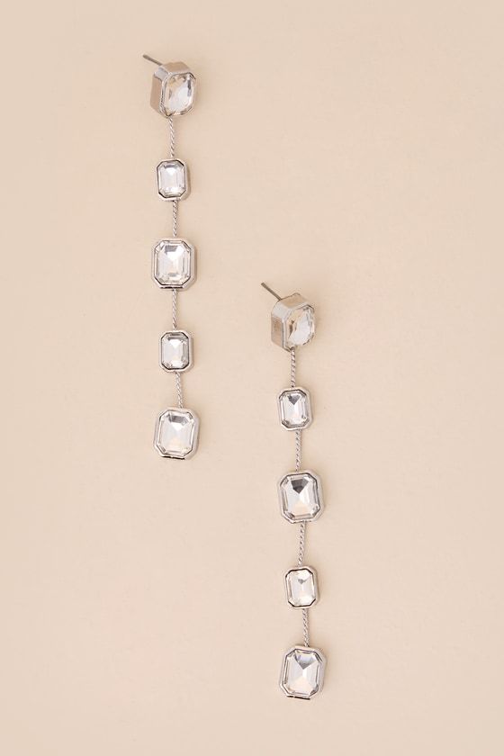 You'll want to sweep your hair back so you can show off the Lulus Deeply Glam Silver Rhinestone Drop Earrings! Shiny, silver-toned metal shapes these elegant and eye-catching earrings that have a swingy silhouette, with glittering rectangular rhinestones that fall along a slender length of chain. Post backs. 4" Long And 25" Wide. 50% Zinc, 30% Glass, 20% Brass. Imported. Lulus | Deeply Glam Silver Rhinestone Drop Earrings. Bridesmaid Earrings Silver, Silver Bridesmaid, Hair Back, Long Drop Earrings, Earrings Long, Silver Rhinestone, Bridesmaid Earrings, Shiny Silver, Silver Glitter