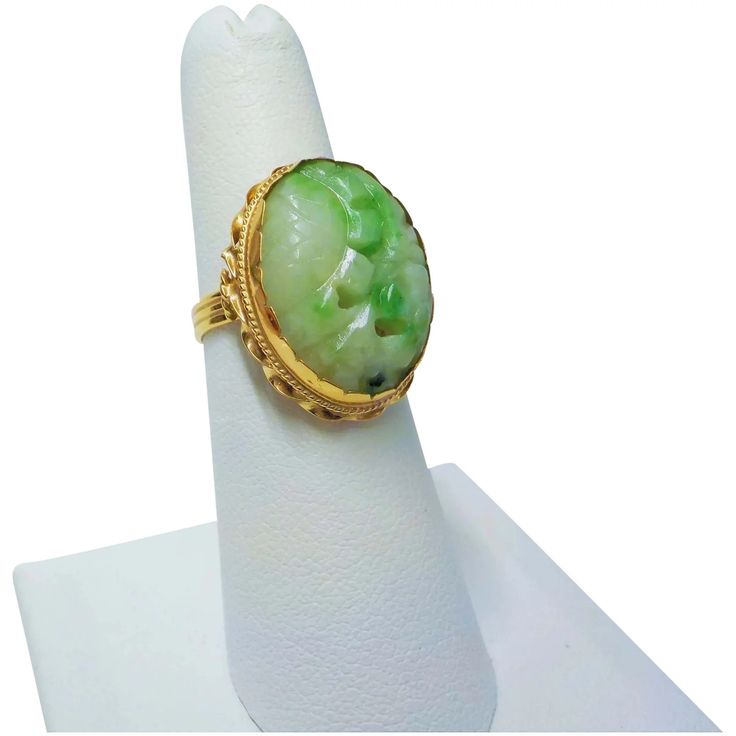 On offer is this beautiful Vintage Chinese Hand Carved Apple Green Jadeite 14 karat Yellow Gold Ring featuring a glistening large oval carved and pierced Green Jadeite gem that has been set into an ornate 14 Karat Yellow Gold Mount. Ring size 6.25 which can easily be sized up or down by a jeweler. Measuring 7/8 inch long x 5/8 inch wide, with the large oval Jadeite cabochon being 3/4 inch x just over 1/2 inch wide and weighing 5.4 grams. In excellent condition with no damage or repairs. Hallmark Oval Carved Jade Jewelry, Carved Oval Jade Jewelry, Fine Jewelry Carved Oval Ring, Gold Apple, Carved Jade, Chinese Export, Jade Ring, Jade Carving, Apple Green