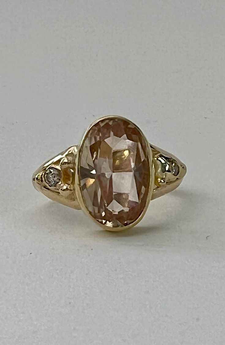 "If you're looking for ultimate sparkle, this is the ring for you!  This light peach colored Oregon Sunstone bursts with sparkle. Champagne diamonds are set on each side. All set in solid 18ct yellow with simple gold bezels and band. The band is a sleek split band, 1/8\" wide. This ring is handcrafted using the best 18ct yellow gold we can buy and we source our stones from responsible suppliers. Oregon Sunstone measures 13 x 8.2mm, weight - 3.26cts Champagne diamonds measure 2.5mm round each, to Classic Morganite Diamond Ring In Yellow Gold, Heirloom Morganite Jewelry In Yellow Gold, Yellow Gold Morganite Jewelry With Center Stone, Gold Morganite Diamond Ring With Center Stone, Heirloom Gold Ring With Morganite, Heirloom Gold Morganite Ring, Gold Morganite Diamond Ring With Prong Setting, Heirloom Morganite Gold Ring, Yellow Gold Morganite Ring With Brilliant Cut