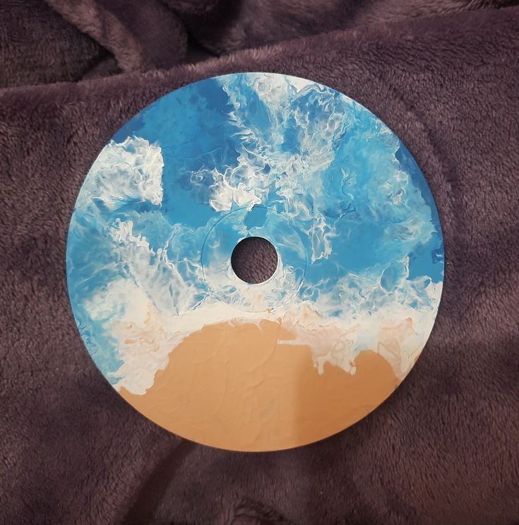 a blue and white circular object sitting on top of a brown blanket