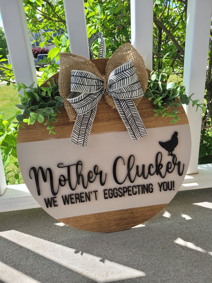 a wooden sign that says mother chickener, we weren't escaping you on the porch