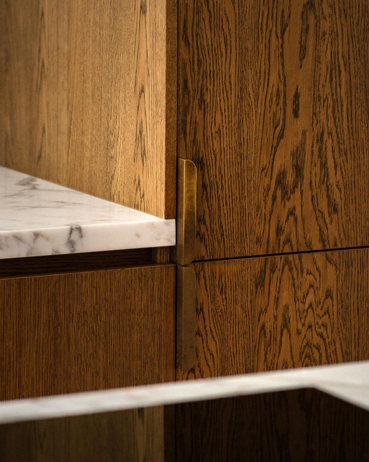 a close up of a wooden cabinet with white marble top and bottom drawer, in an office setting