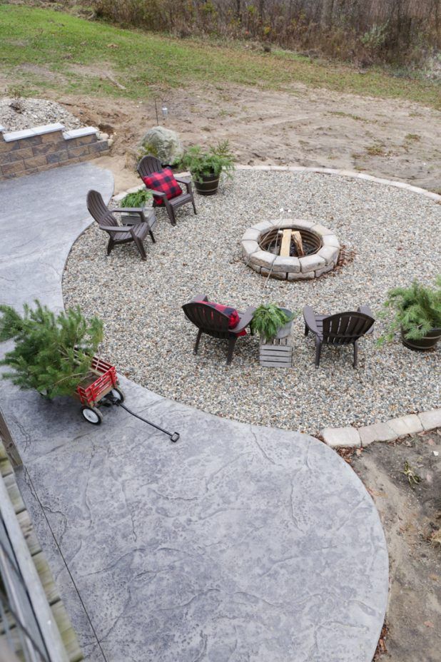 an outdoor fire pit surrounded by chairs and trees