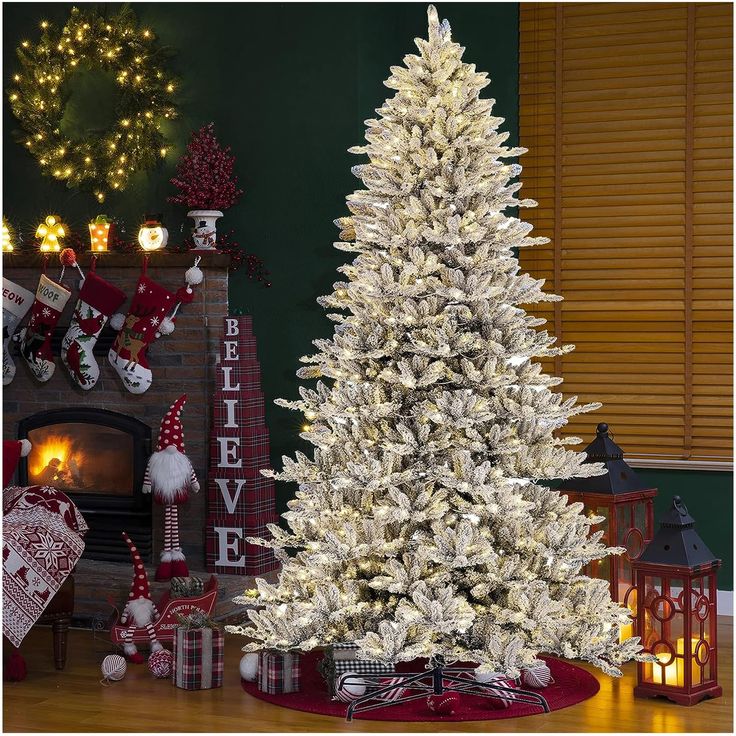 a white christmas tree in front of a fireplace