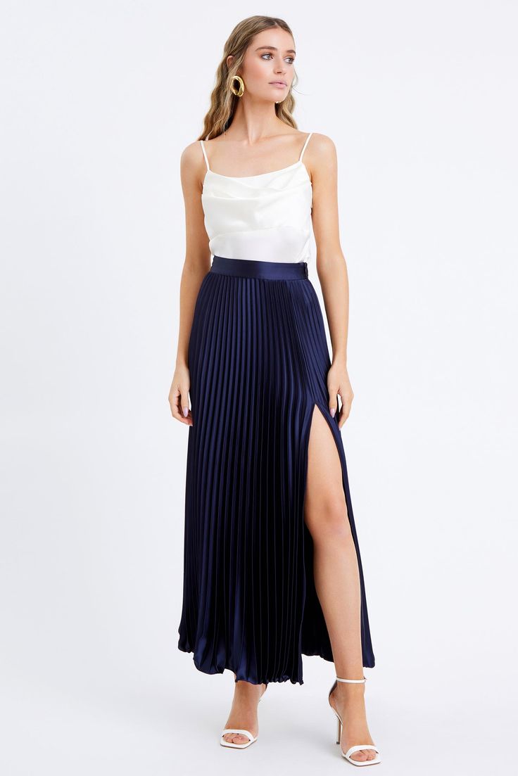 Discover timeless elegance with the Honor Pleated Maxi Skirt. Crafted from luxurious satin fabric, this maxi skirt is perfect for the modern sophisticate. The tall side slit adds a touch of drama, while the pleats create a timeless look that will never go out of style. Versatile with any blouse and for any occasion. Maxi skirt Pleated Side slit Length: 39 7/8" Waist: 13 3/4" Self: 97% Polyester, 3% Spandex Model is wearing a size small Style #: F2311S9316 Navy Pleated Skirt Outfit, Pleated Maxi Skirt Outfit, Blue Maxi Skirt Outfit, Navy Silk Skirt, Movie Core, Maxi Skirt Outfit Summer, Blue Skirt Outfits, Skirt Outfits Aesthetic, Skirt Outfit Summer