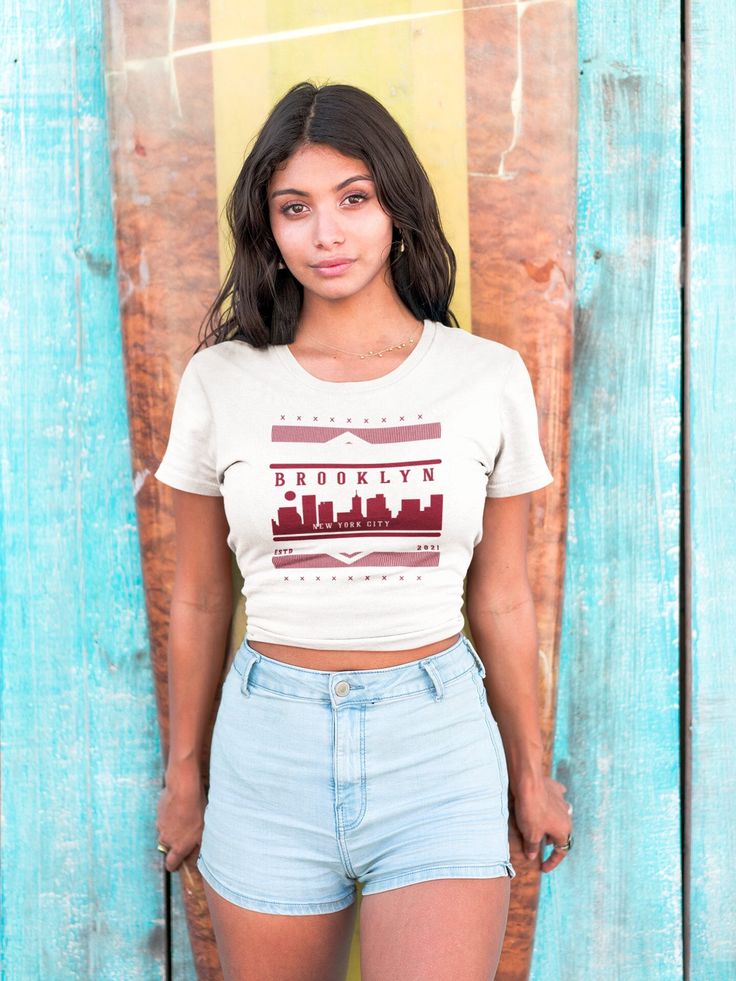 Dress in urban elegance with our 'Brooklyn Skyline Bliss' tee - a stylish tribute to the iconic cityscape. Crafted for comfort and adorned with the pride of Brooklyn, this shirt is a perfect blend of fashion and city spirit. The eye-catching skyline design reflects the charm of New York City, making it a must-have for those who appreciate urban chic. Show off your Brooklyn pride in every thread and embrace the city vibes wherever you go. Elevate your wardrobe with this unique tee that captures t Graphic Cotton Tee For Urban Adventures, Graphic Tee Cotton Top For Urban Adventures, Crew Neck Cotton Top For Urban Adventures, Cotton Crew Neck Top For Urban Adventures, Urban Fitted T-shirt With Letter Print, Graphic Print Crew Neck Top For Urban Adventures, Casual Crew Neck Tops For Urban Adventures, Urban Style Tops With Screen Print, Urban Pre-shrunk Crew Neck Top