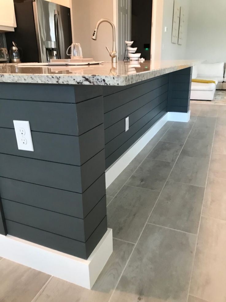 a kitchen with gray walls and white trim on the countertops, along with an island in the middle