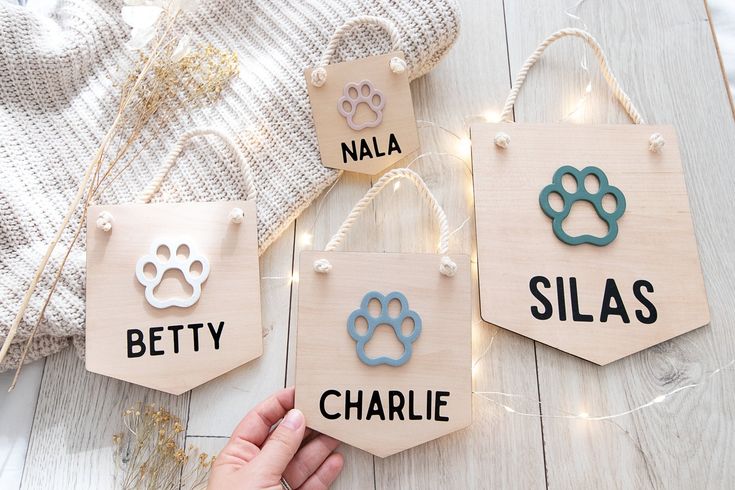 handmade wooden name tags with dog's names and paws hanging from string lights