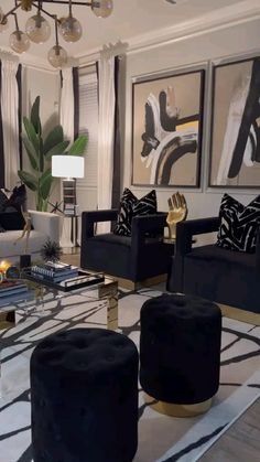 a living room filled with black and white furniture next to a painting on the wall