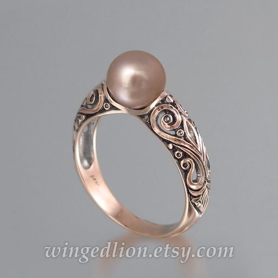 BEATRICE ring was designed by the artist and jewelry designer Sergey Zhiboedov. It will be made to order in 14K gold in the size specified by the customer.The shank is adorned with intricate scroll carvings. The ring features a beautiful pink freshwater pearl (7-7.5mm in diameter). The crown is about 8mm high (including the stone) and 7.5mm wide. The widest part of the shank is 5.9mm. The ring can be made in sizes from 4 to 9. The sample ring shown in the photos is size 6.75.The ring is shown wi Elegant White Gold Engraved Ring Stamped 14k, Elegant Rose Gold Engraved Ring, Exquisite Engraved Rings For Formal Occasions, Elegant Rose Gold Engraved Ring Stamped 14k, Elegant Engraved Promise Ring, Elegant 14k Gold Engraved Ring, Elegant Sterling Silver Engraved Ring, Elegant Gold Engraved Ring In Sterling Silver, Elegant Hallmarked Rose Gold Ring