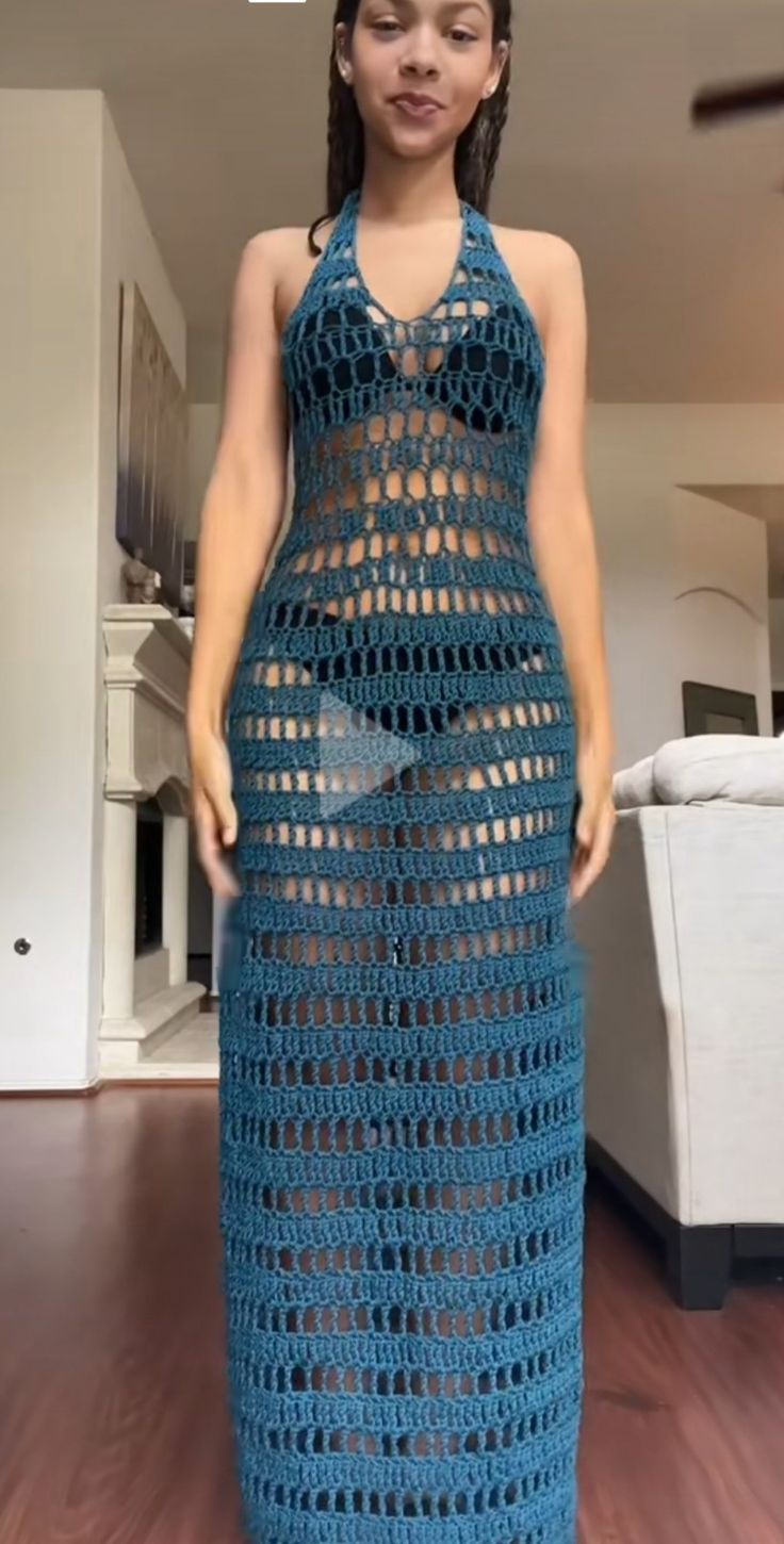 a woman wearing a blue crochet dress in a living room