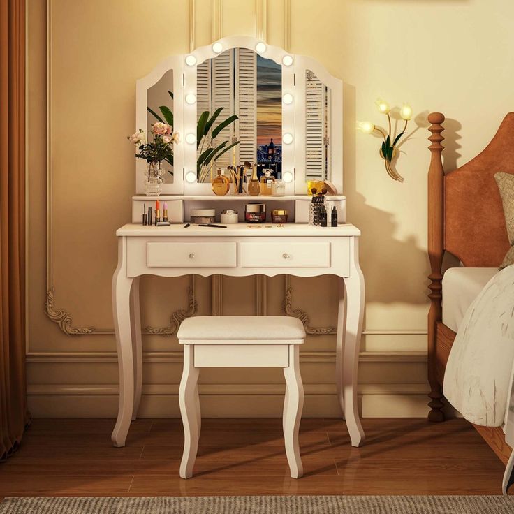 a white vanity table with a mirror and stool next to it on a wooden floor