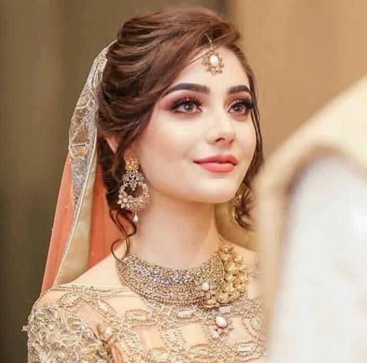 a woman wearing a bridal outfit and jewelry