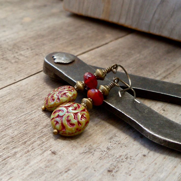 These colors just drew me in! They are so rich and beautiful together. I now have a whole selection of beads that will mix and match with this series. When I look at these, I initially think fall or autumn, then I gravitate to considering Christmas. These items are all available with antique brass or copper. Every earring is available with titanium ear wire, if you need them for your sensitive ears. Even if you don't need them, they look and feel great. These long dangle earrings are perfect for Vintage Beaded Earrings For Gift, Handmade Red Plug Earrings As Gift, Red Metal Beaded Drop Earrings, Red Brass Earrings With Ear Wire, Red Brass Drop Earrings, Bohemian Red Nickel-free Earrings, Unique Handmade Red Earrings, Bohemian Red Dangle Earrings, Red Bohemian Dangle Earrings