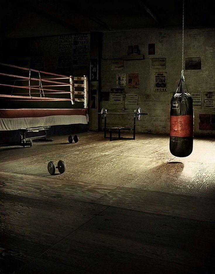 a boxing ring with two punching gloves hanging from the ceiling and other equipment on the floor