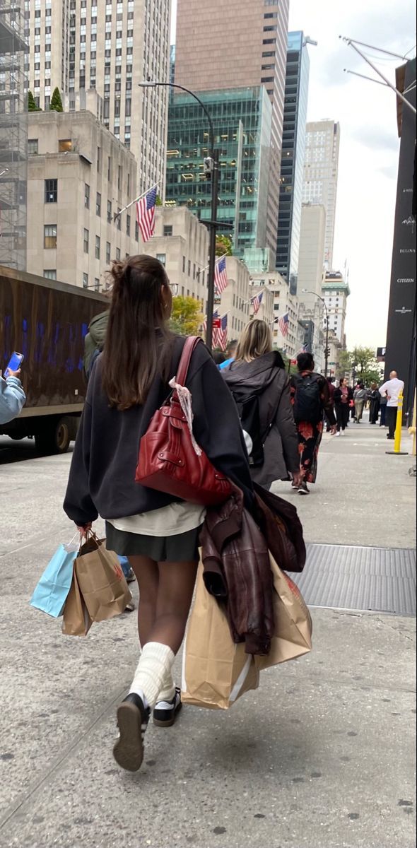 two women walking down the street carrying shopping bags