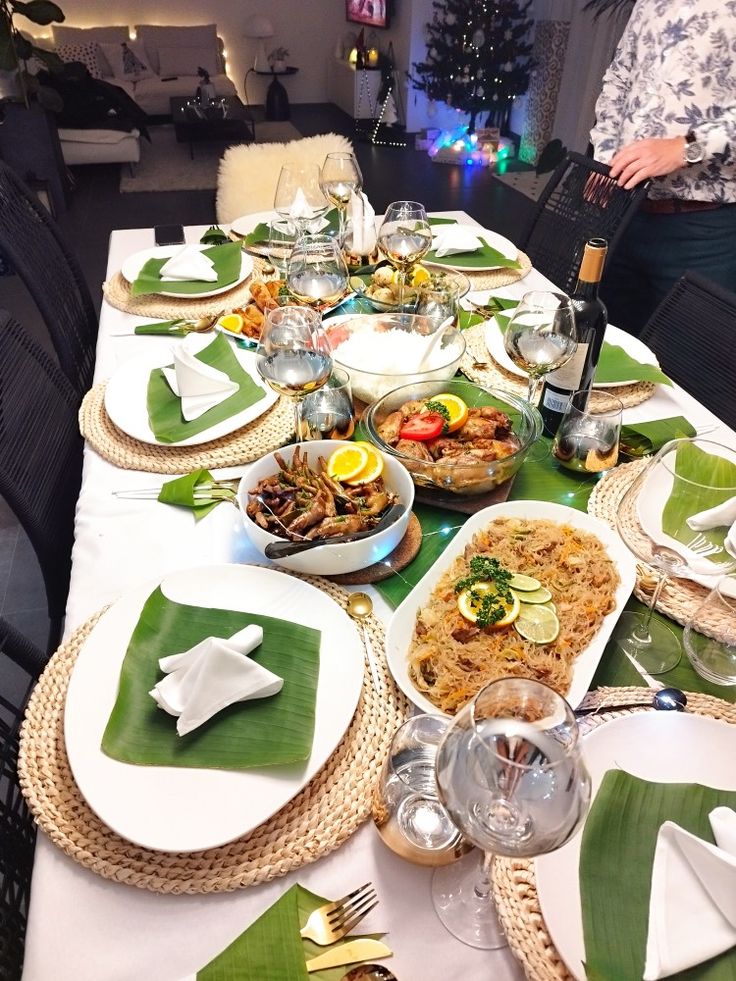 a table set with plates, silverware and green napkins for an elegant dinner