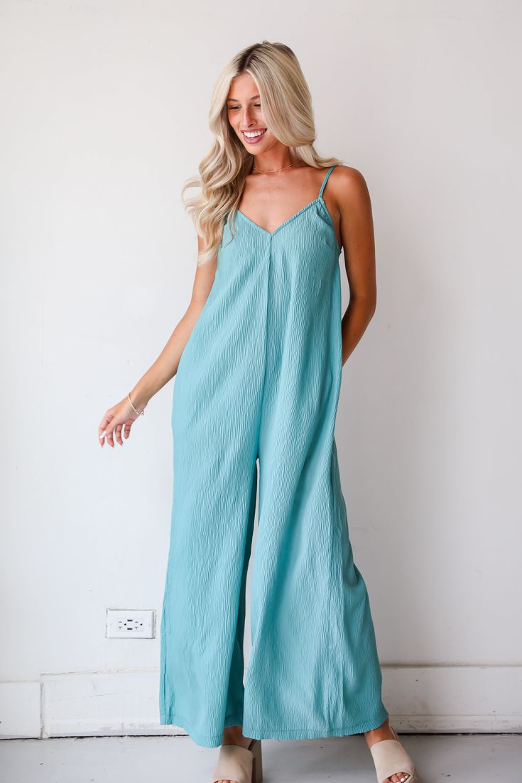 Greet warm days and blue skies with a perfect look like the Sunny Energy Teal Wide Leg Jumpsuit! Crafted from luxurious, flowy fabric in a rich teal hue, this jumpsuit exudes elegance and sophistication, perfect for any occasion. The jumpsuit features a flattering V-neckline that elongates the silhouette and draws the eye upward. The sleeveless design keeps you cool and allows for easy layering, while the fitted bodice accentuates your curves before flowing into stylish wide legs that elongate t Blue Maxi Length Jumpsuits And Rompers For Spring, Blue Maxi Length Jumpsuits For Spring, Spring Loungewear Jumpsuits And Rompers, Flowy Fit, Spring Flowy Loungewear Jumpsuits And Rompers, Flowy Spring Loungewear Jumpsuits And Rompers, Solid Color Spring Maxi Jumpsuits And Rompers, Solid Color Maxi Length Jumpsuits And Rompers For Spring, Blue Summer Jumpsuits And Rompers For Loungewear, Blue Jumpsuits And Rompers For Summer Brunch