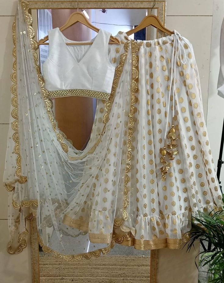 Ready to wear white georgette lehenga blouse for women. Plus size available at a small up-charge. Size: This is custom made outfit as per your size. Post your order we will send you a measurements reference sheet using which you can provide details required to make your outfit with best fit. Fabric and work:  Lehenga - Embroidered georgette. Blouse - Silk with embroidery border lace. Dupatta - Sequins work net. Delivery time: This lehenga set will take 2-3 weeks to produce after we have received your sizing details. Don't worry it can be made sooner too, just keep us informed, we will process it accordingly and deliver on or before a delivery date we discuss. Disclaimer: Color may slightly vary due to digital photography and display screen settings. Laces and trims may change based on avai White Pre-draped Saree With Gota Work For Navratri, White Georgette Saree Dress, White Anarkali Choli For Party, White Choli With Self Design, Festive White Choli With Sheer Dupatta, White Unstitched Choli For Designer Wear, White Semi-stitched Choli With Sheer Dupatta, White Georgette Dress With Zari Work, Designer White Unstitched Choli