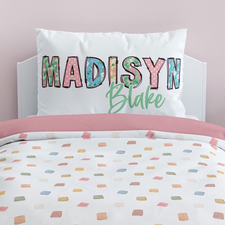 a bed with a pillow that says madison bake on it and colorful polka dots