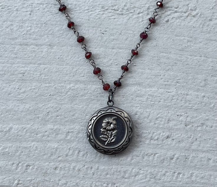 This necklace is handmade with a 3mm genuine garnet rosary chain and a flower locket pendant. The locket opens up so you can place a photo inside.  This necklace is hypoallergenic. (Cadium free, lead free, and nickel safe) Garnet is an energizing stone that promotes passion and love.  The necklace comes in a ribbon-wrapped box, ready to be gifted. If you would like to leave a note, you can do so during checkout. Necklaces Ideas, Necklaces Handmade, Handmade Pendant Necklace, Mazzy Star, Crystal Necklaces, Dope Jewelry, Rosary Chain, Jewelry Lookbook, Funky Jewelry