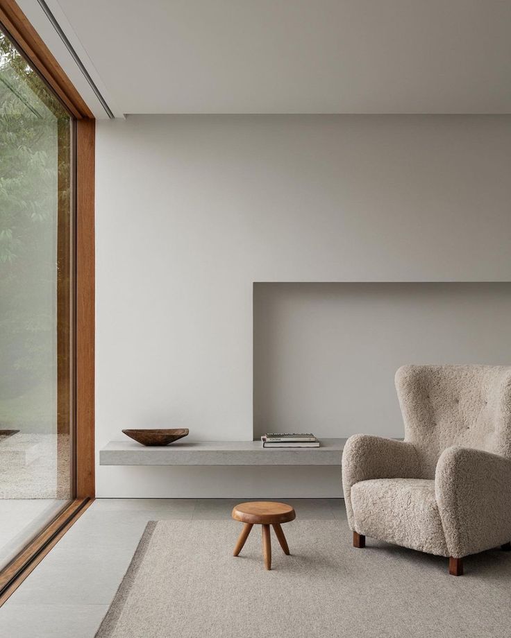 a living room with a chair and table next to a large sliding glass door that looks out onto the outdoors