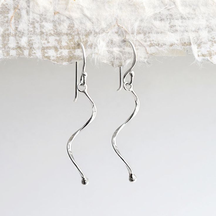 Our Sterling Silver Dangly Simple Wave Earrings are a fantastic pair of fun, every day earrings These light and delicate sterling silver earrings would add a subtle touch of elegance to any outfit or occasion. They're design and polished finish gives them a wonderfully understated presence and shine. So why not treat some family or friends to these great little earrings, priced so well you could even treat yourself. All Martha Jackson jewellery comes complete with a gift box and gift card for you to write a short message on Made from Sterling Silver, keep shiny with an anti tarnish cloth Dimensions Wave length 3cm. Overall length 4.2cm Sterling Silver Drop Earrings With A Modern Twist, Modern Twist Sterling Silver Drop Wrap Earrings, Modern Twist Sterling Silver Drop Earrings, Modern Twist Dangle Earrings As Gift, Modern Twist Dangle Earrings For Gift, Modern Twist Nickel-free Drop Earrings, Dainty Silver Drop Wrap Earrings, Everyday Silver Earrings With A Modern Twist, Modern Twist Silver Earrings For Everyday