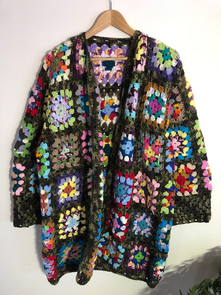 "Hand Crochet Granny Square Cardigan Size: Large to Extra Large depending on how you like to wear a sweater/ cardigan. Who says you can't leave the house with your blanket. This beautiful and colourful boho jacket is super comfy and easy to wear. Great for any body types and sizes. Lightweight and great  for any season. Hand crochet, just for you. Wash by hand with mild soap and cool water. Squeeze excess water out ( don't twist). Roll up in a towel to get excess water out and lay flat to dry completely. No hanging when wet as garment will stretch out of shape. Measurements taken while laying flat Neck is v line Pit to Pit 24\" Sleeves from pit to cuff 14\" Front from shoulder to bottom 35\" Back from shoulder to bottom 35\" Purchase price includes free shipping in Canada and the USA Inter Bohemian Multicolor Outerwear For Fall, Multicolor Bohemian Outerwear For Fall, One Size Cozy Outerwear For Festivals, Cozy One Size Outerwear For Festivals, Colorful One Size Cardigan For Fall, Colorful One Size Fall Cardigan, One Size Hippie Outerwear For Fall, Vintage Multicolor Cardigan For Fall, One Size Bohemian Sweater Coat For Fall