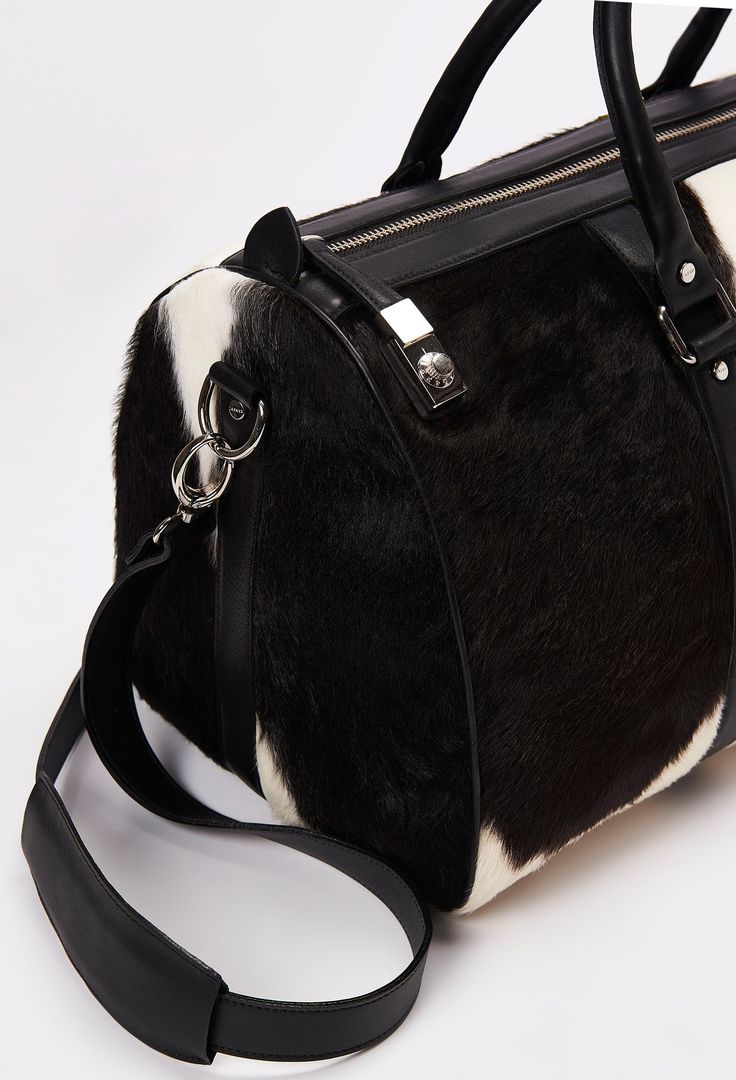 Our Pampa Cowhide Weekender distinguishes easily, and will definitely catch the attention of everyone around you. Handcrafted in our Cowhide, this Weekender is a unique and inimitable piece. Apart from being beautiful, it keeps your essentials secure by a padlock that gives access to the zip closure. Generously-sized, ideal to take a break on weekends. Carry it by its rugged luggage handles or use the detachable all-leather crossbody strap for hands-free wear. Dimensions- Height 11,4" - Length 2 Designer Leather Travel Bag With Top Carry Handle, Luxury Satchel For Weekend Trips With Top Carry Handle, Luxury Duffle Bag Satchel For Weekend Trips, Luxury Satchel Tote For Overnight Trips, Luxury Satchel Duffle Bag For Weekend Trips, Luxury Weekend Trip Duffle Bag Satchel, Luxury Satchel For Overnight Trips With Leather Handles, Luxury Weekender Satchel Bag For Overnight Trips, Luxury Satchel With Leather Handles For Overnight Trips