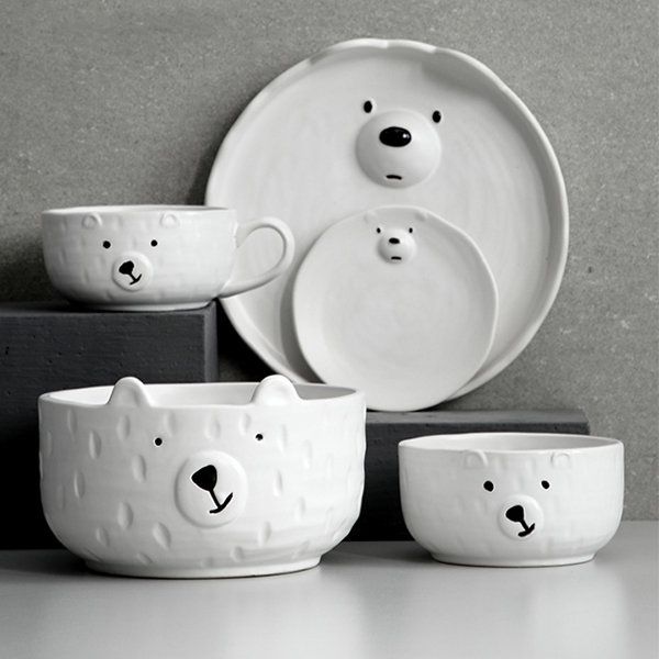 three white bowls with bears on them sitting next to each other in front of a plate