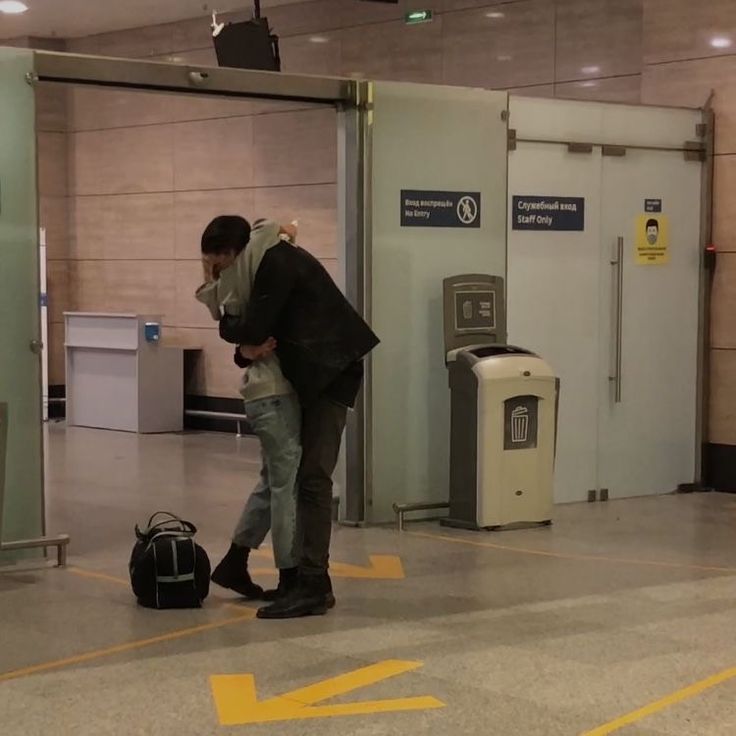 a man standing in an airport with his luggage