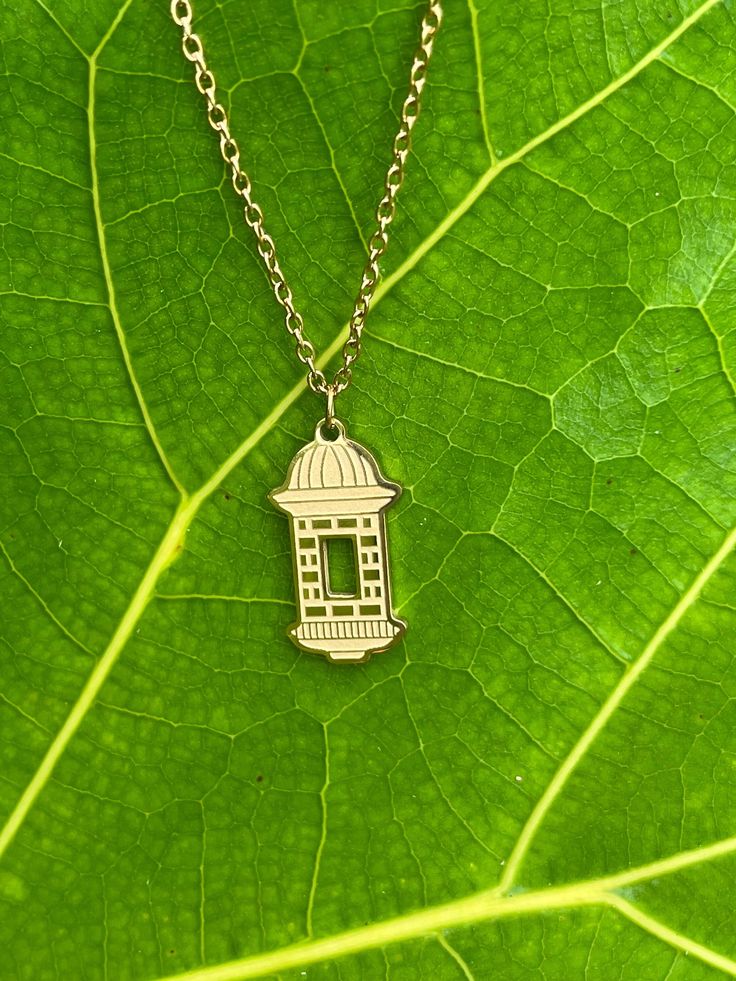 Garita del Morro pendant with chain made of Stainless Steel. The gold one has a gold plating. This Puerto Rico themed necklace is a great way to keep "La Isla del Encanto" close to your heart. Unisex Puerto Rican Jewelry. The Garita charm measures 13/16" tall and 1/2" wide.  The chain measures 2mm wide and I offer different length options. The chain will include a 2" extension so that you can adjust it to your desired length.  Garita (Sentry Box in English) is the name of the structures used as Gold-tone Locket Chain Necklace As Gift, Gold-tone Chain Necklace With Locket For Gift, Gold-tone Brass Charm Necklace For Gift, Gold-tone Chain Charm Necklace For Gift, Gold Locket Chain Necklace As Gift, Gold Locket Chain Necklace For Gift, Brass Charm Necklace With Chain As A Gift, Brass Charm Necklace With Box Chain As Gift, Brass Charm Necklace With Box Chain For Gift