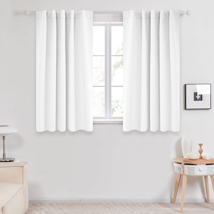 a room with white curtains and a table