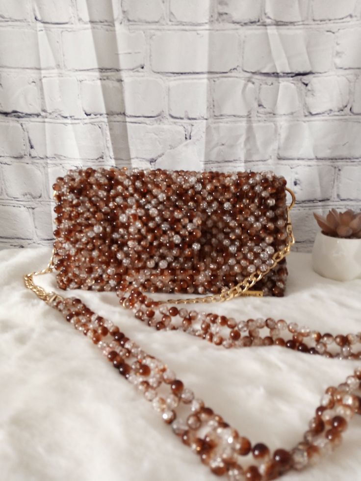 Carry a little extra sparkle wherever you go with this stunning beaded bag. Dimension: Width: 21.5cm Height: 11cm Depth: 6cm The bag comes with a detachable handle which measures 110cm. Feel free to contact me for any questions. Trendy Beaded Clutch Shoulder Bag, Trendy Brown Clutch For Party, Trendy Handheld Beaded Evening Bag, Beaded Crossbody Shoulder Bag For Evening, Beaded Evening Crossbody Bag, Evening Beaded Crossbody Bag, Trendy Brown Evening Bag For Party, Handmade Brown Evening Bag For Party, Beaded Shoulder Bag Clutch