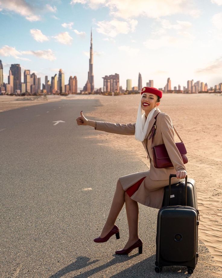 a woman sitting on top of a piece of luggage