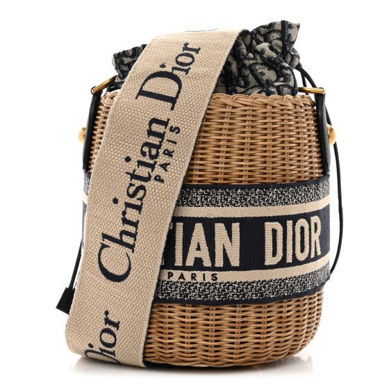 This is an authentic CHRISTIAN DIOR Wicker Oblique Drawstring Bucket Bag in Blue. This small bucket-style bag is crafted of wicker with Dior monogram canvas and blue leather and embroidered Christian Dior logo trim. The bag features an adjustble beige and blue canvas shoulder strap and aged gold hardware. The center canvas interior opens with a cinch cord to a patch pocket. Luxury Woven Leather Bucket Bag, Designer Natural Straw Bucket Bag, Designer Natural Bucket Straw Bag, Designer Woven Bucket Bag, Designer Natural Bucket Bag For Travel, Luxury Beige Basket Bucket Bag, Designer Woven Leather Bucket Straw Bag, Designer Woven Leather Straw Bucket Bag, Designer Woven Bucket Shoulder Bag