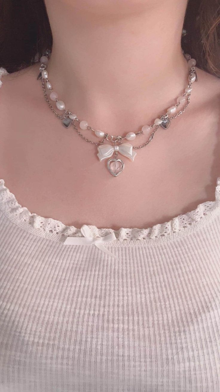 Add a touch of elegance and whimsy to your jewelry collection with our Pink Coquette Necklace with a Bow & Heart Charm. This dainty layered pearl necklace combines timeless sophistication with playful charm, making it the perfect accessory for any occasion. Handcrafted with care, this princess jewelry piece features lustrous freshwater pearls and delicate rose quartz beads, exuding a sense of luxury and femininity. The adorable bow and heart charm add a unique coquette flair, making this necklac Luxury Beaded Jewelry, Bow Necklace Beads, Collares Coquette, Coquette Necklace, Necklace Princess, Layered Pearl Necklace, Princess Jewelry, Pearls Jewelry, Pink Coquette