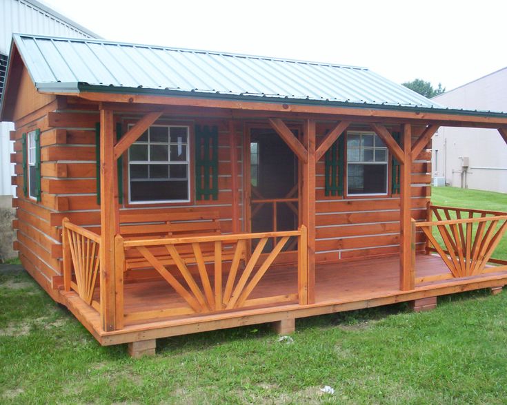 a small wooden cabin sitting on top of a lush green field