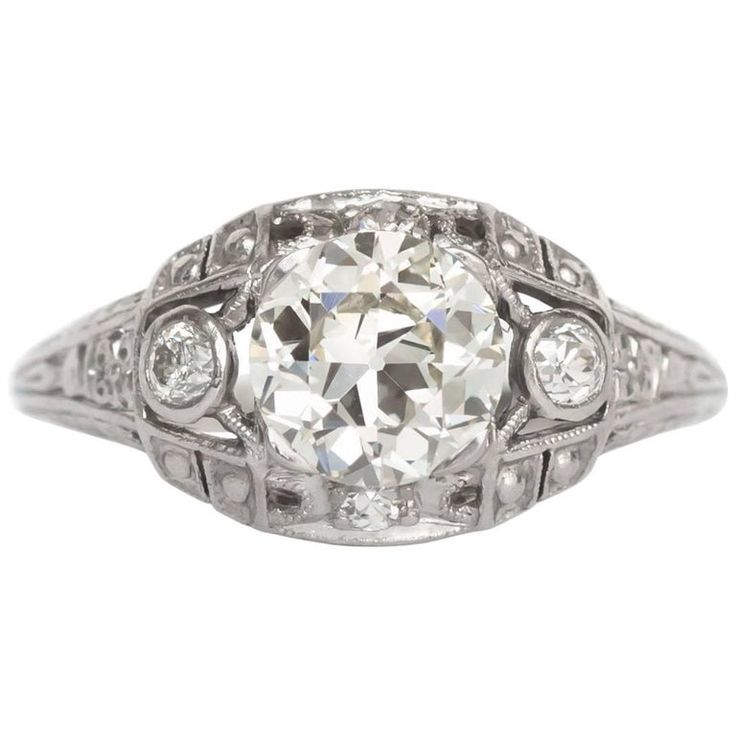 an antique style diamond ring with filigrees on the sides and round brilliant cut diamonds