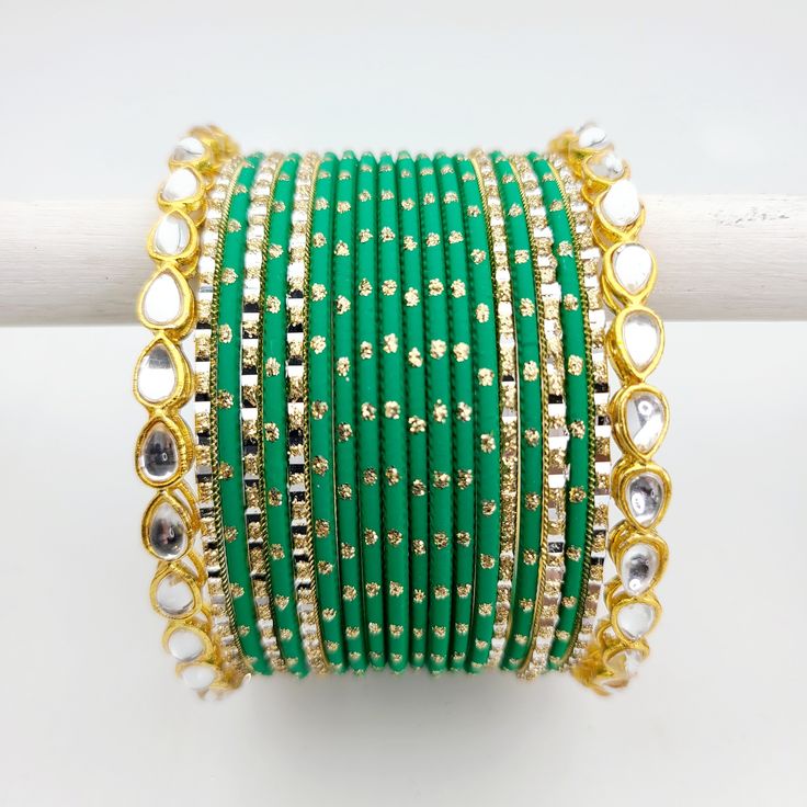 Bangle set comes with 2 sets - 1 per arm. Feel free to mix and match on your own! Step into a world of timeless elegance with our exquisite Kundan gold-plated bangle set, adorned with matte green and accentuated by dazzling gold glitter and gold bangles featuring intricate Kundan work that showcases the intricate beauty of traditional Indian craftsmanship. The bright green adds a vibrant pop to your ensemble, while the gold bangles provide a touch of opulence and sophistication. Love the fusion Green Bangle Bracelets For Wedding, Adjustable Green Bracelets For Celebration, Elegant Green Bangle For Festive Occasions, Adjustable Green Bracelet For Celebration, Green Bracelets For Wedding And Festive Occasions, Elegant Green Bracelets For Festive Occasions, Festive Green Bracelets For Wedding, Green Wedding Bracelets For Festive Occasions, Green Festive Wedding Bracelets