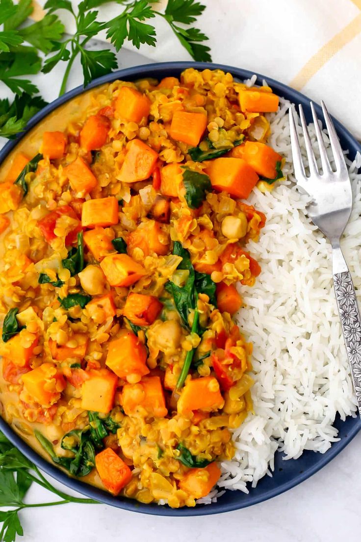 a plate filled with rice and vegetables next to a fork