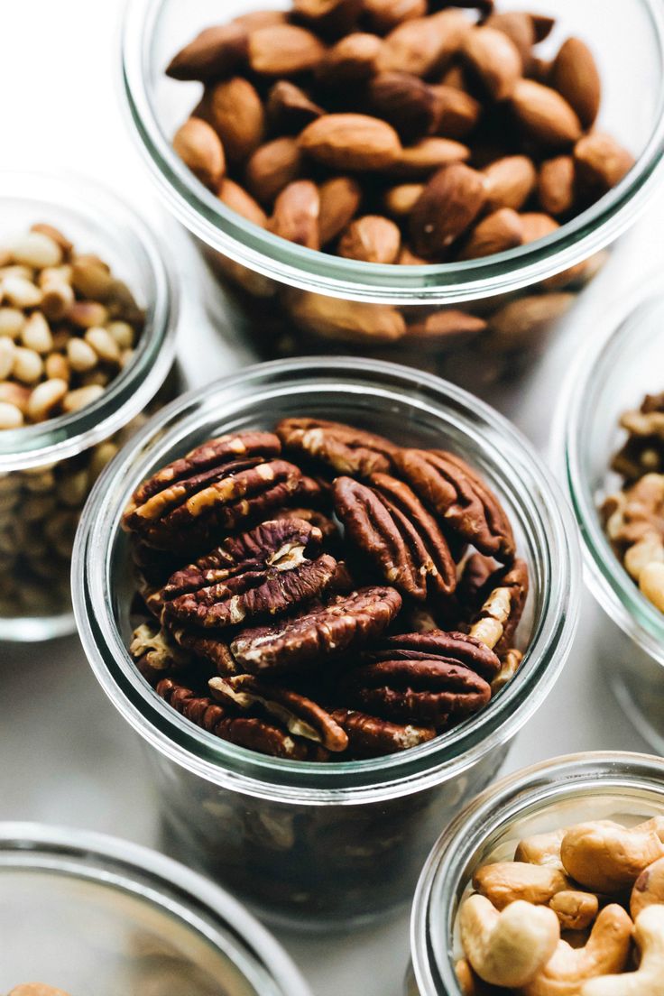 several glass bowls filled with nuts on top of a table